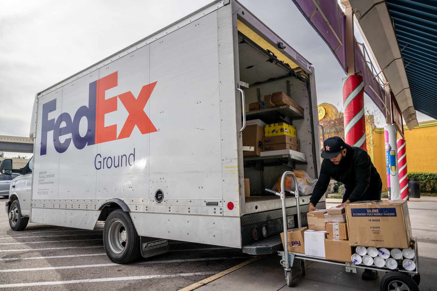 FedEx mail deliver organizes packages at a FedEx facility