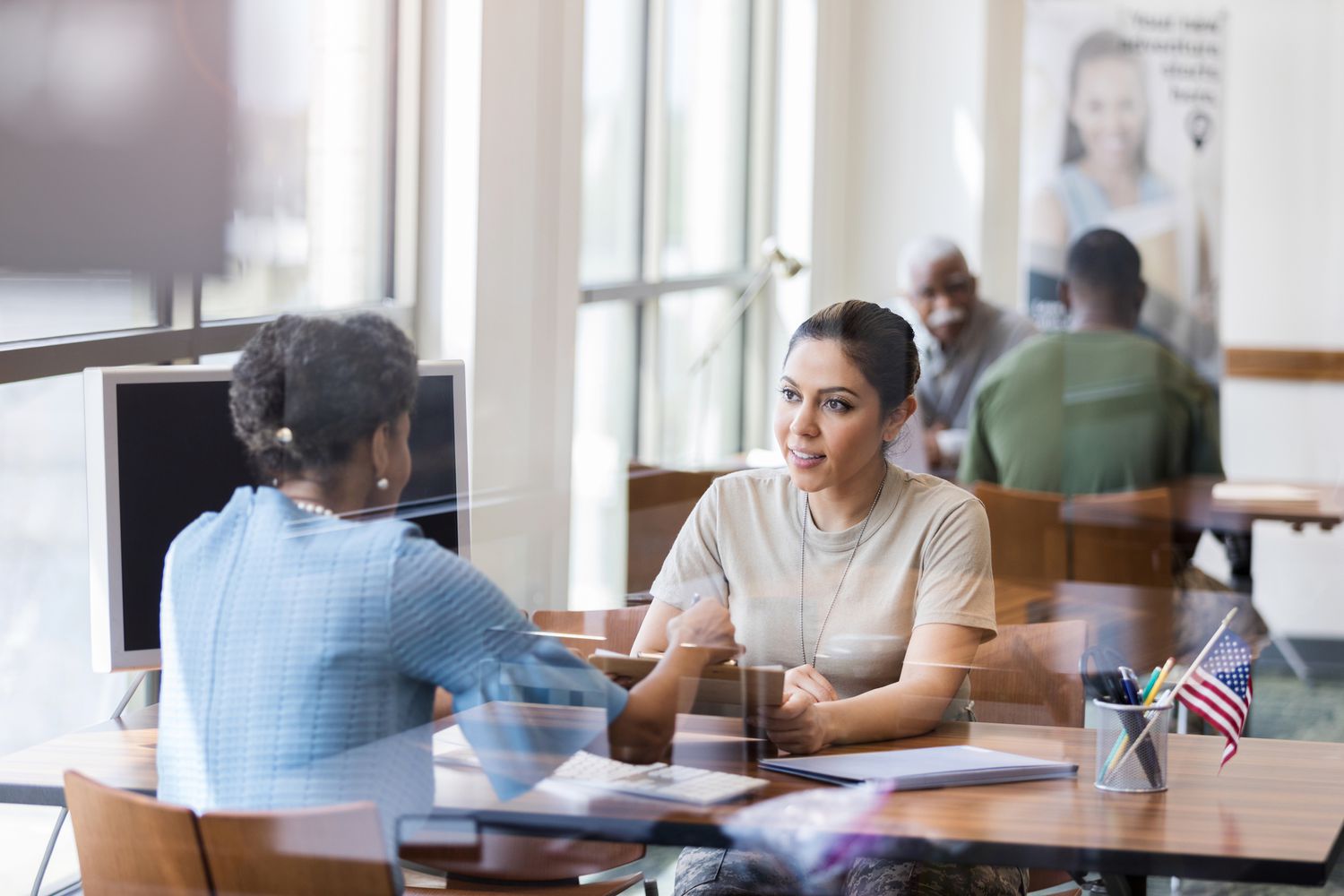 Two women review paperwork at a bank