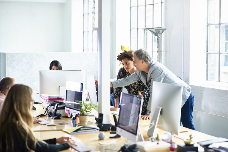 Man and woman looking at computer in modern office.