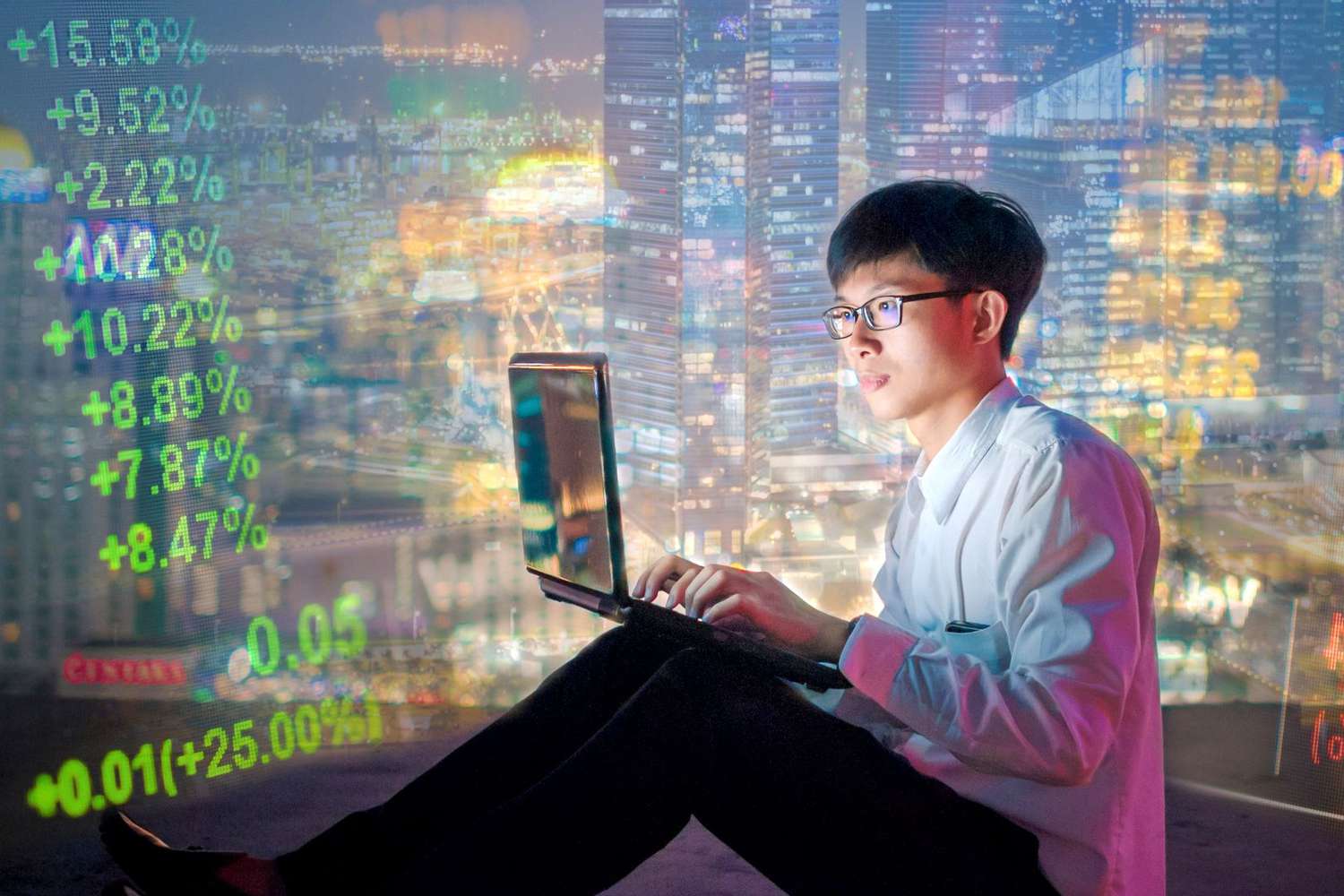Asian man in glasses with a laptop, trading cryptocurrencies