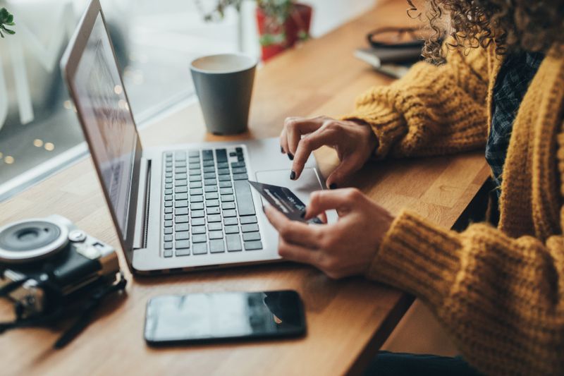 A shopper uses a laptop to enter a transaction authentication number for the credit card they are using for the online purchase.