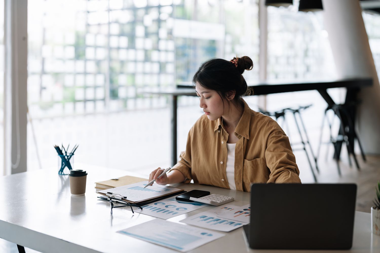A woman reviews data at a desk.
