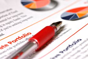 A pencil laid over a portfolio description sheet.