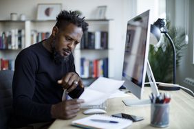 Man working with papers and a computer 