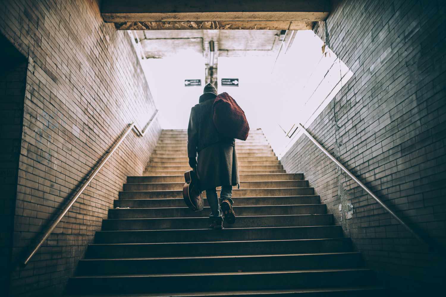 A man walking up the steps in a subway station