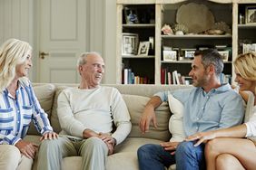 Family with senior parents and two adult children spending leisure time at home