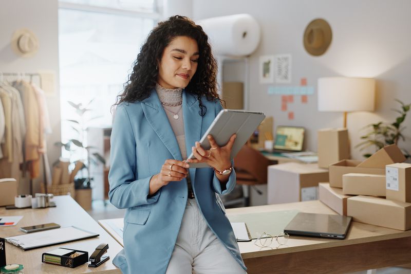 Female person or entrepreneur working on technology in storage or inventory check at retail store or shop