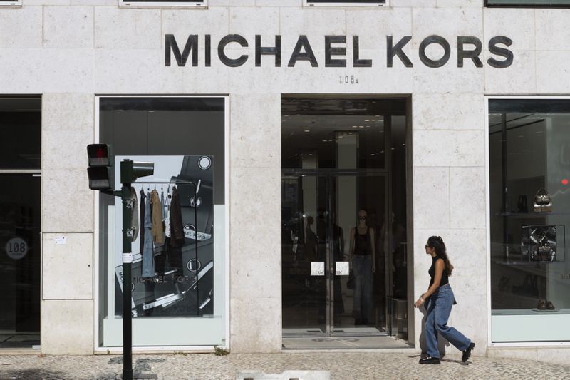 People walk by a Michael Kors store in Lisbon, Portugal.