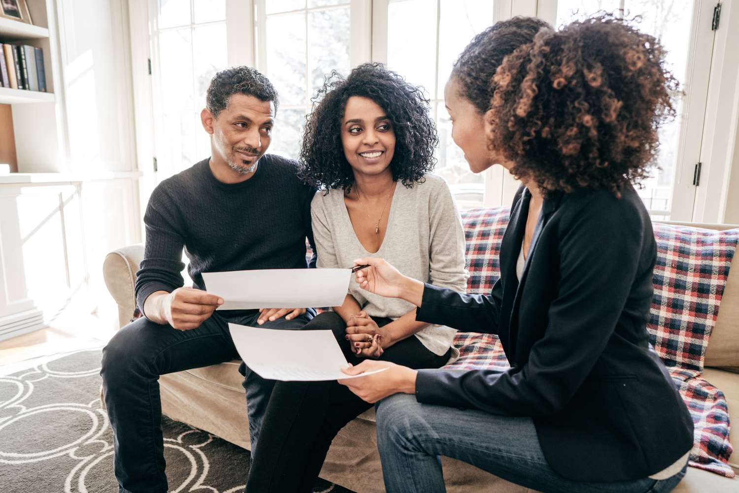 A couple meets with a mortgage broker in their home. 