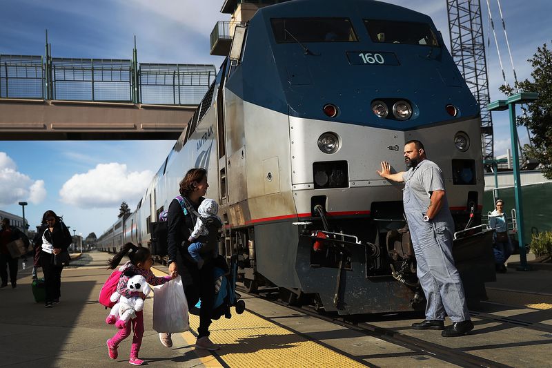 An Amtrak engineer leans on the locomotive as passengers disembark from Amtrak's California Zephyr at the end of its daily 2,438-mile trip to Emeryville/San Francisco from Chicago that took roughly 52 hours on March 25, 2017 in Emeryville, California.