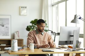 Person wearing glasses using desktop computer 