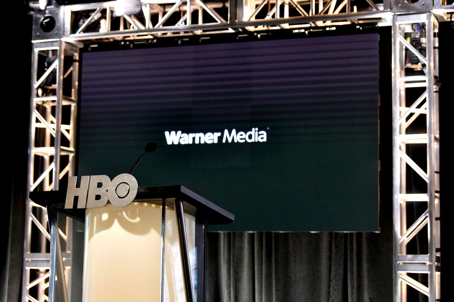 Podium bearing HBO logo in front of screen displaying WarnerMedia logo at an entertainment industry event.