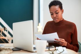 Woman Working on Her Finances at Home, Filling Out Tax Forms
