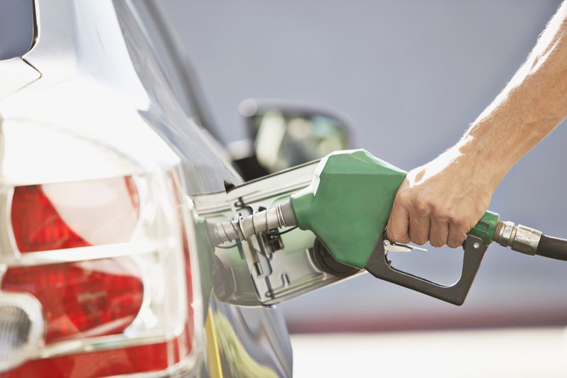 Close up of person fueling their car at a gas station