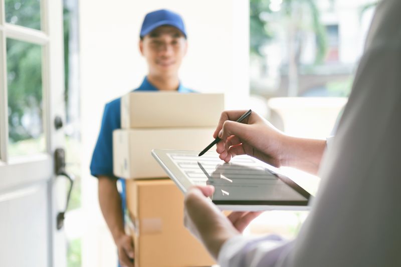Someone signing for boxes delivered by a deliveryman