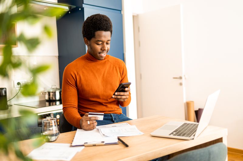 Young African American man checking his credit card's grace period