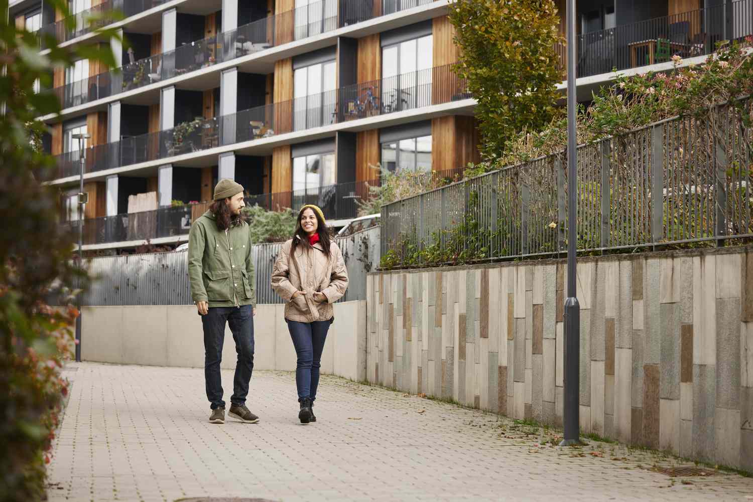 A man and a woman walk through an apartment complex