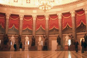 People wander around and look at statues in the Old Hall of Representatives in the U.S. Capitol building in Washington, D.C.