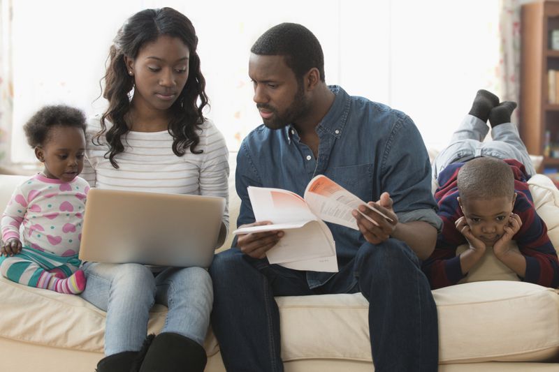 Stressed parents paying bills on laptop