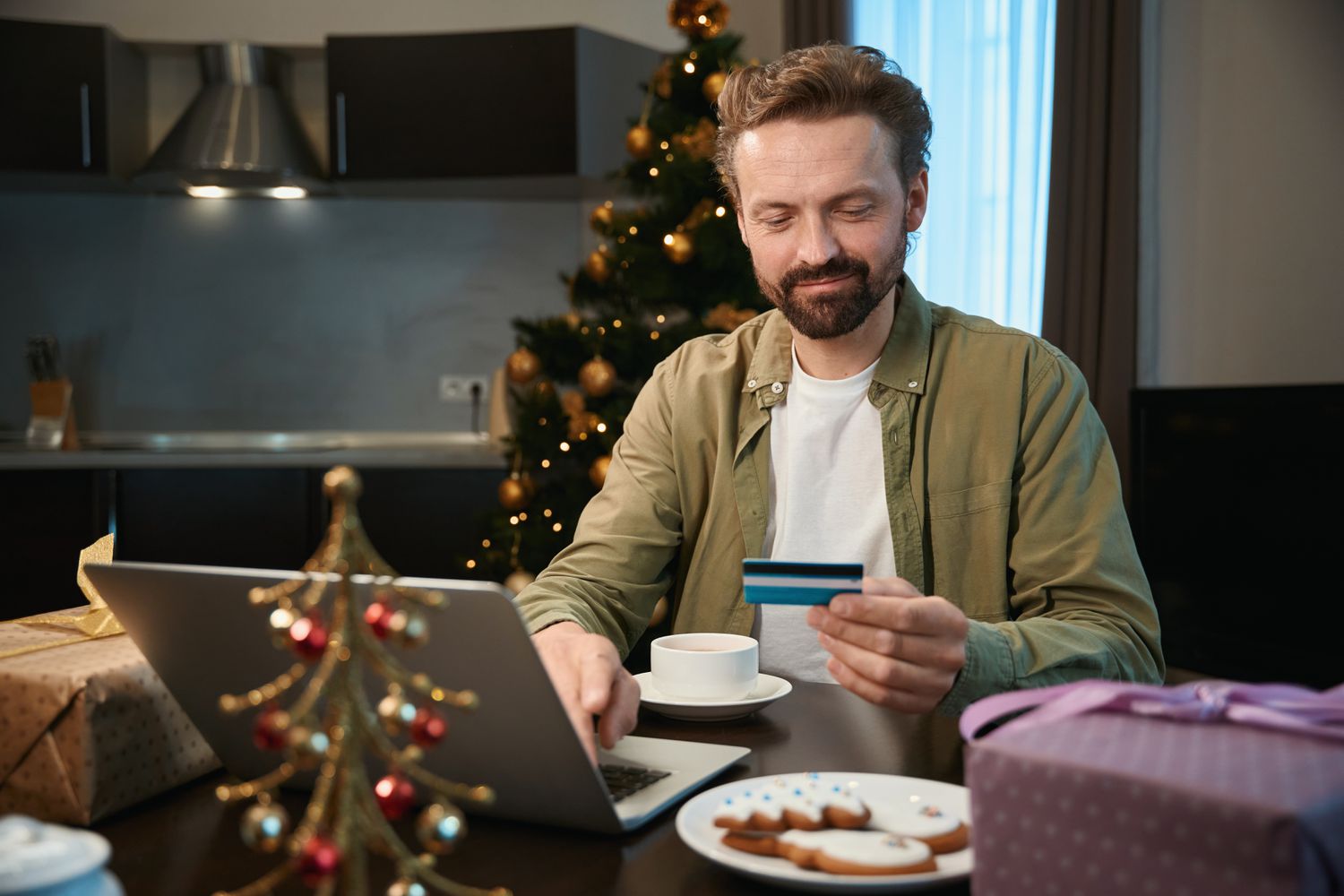 Man using his credit card to pay loan on his laptop