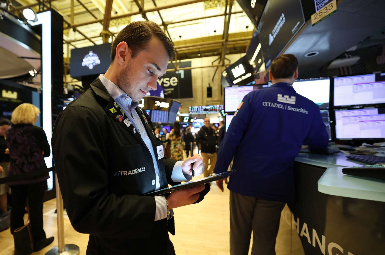A trader looks at a tablet on the floor of the New York Stock Exchange