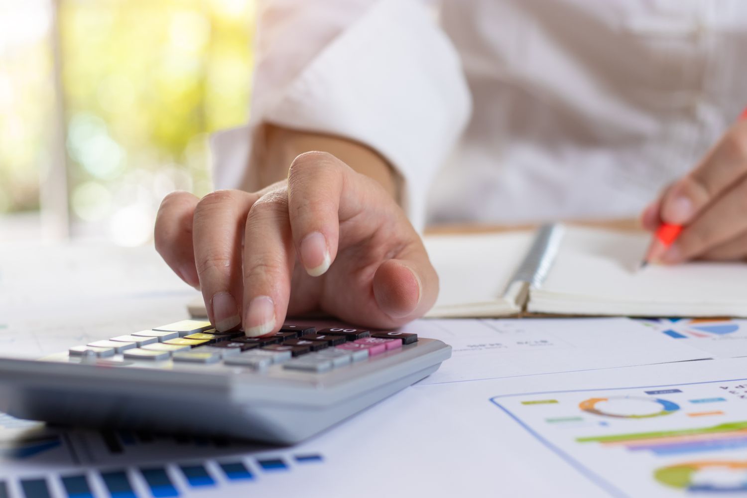 An accountant using a calculator on the desk.