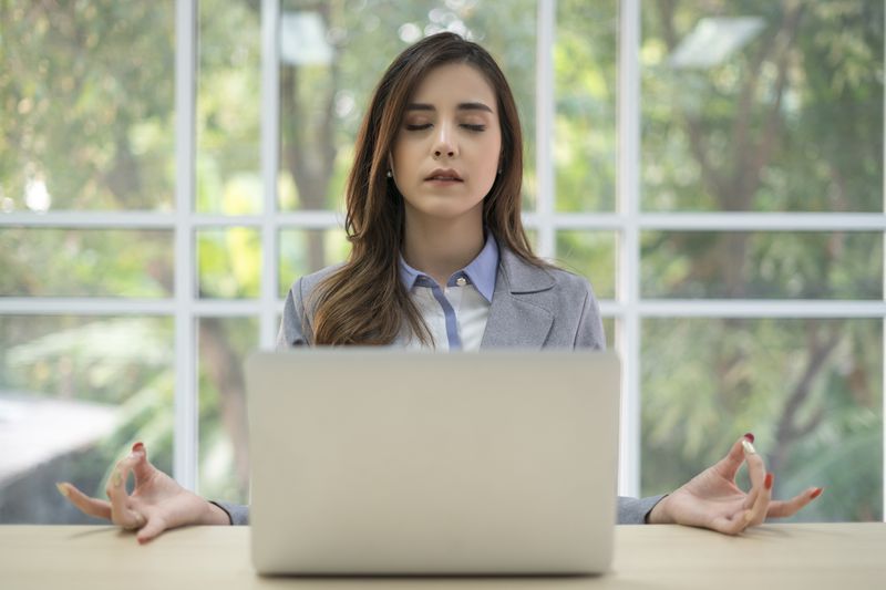 A woman doing yoga at her desk