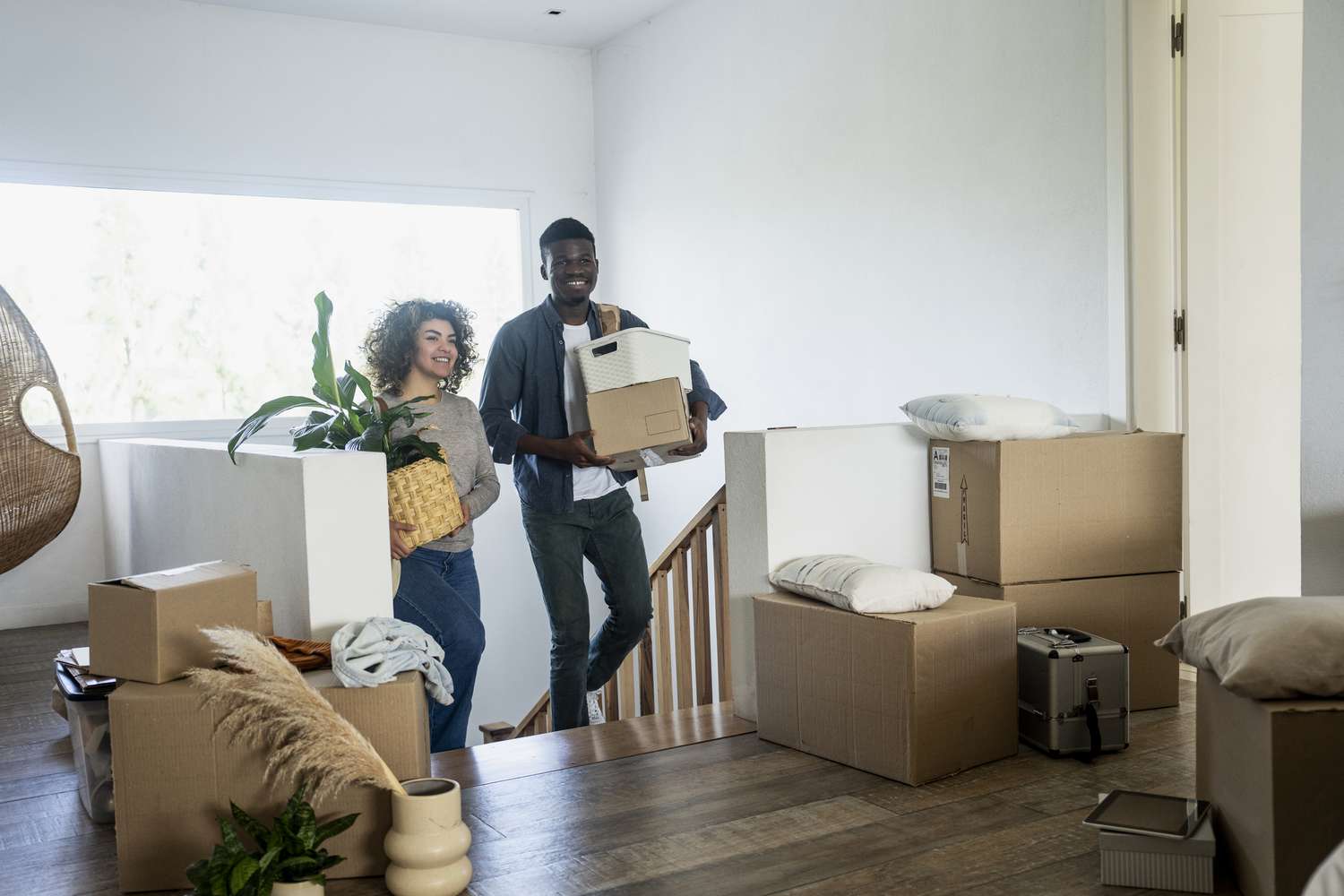 Two people with moving boxes in a house