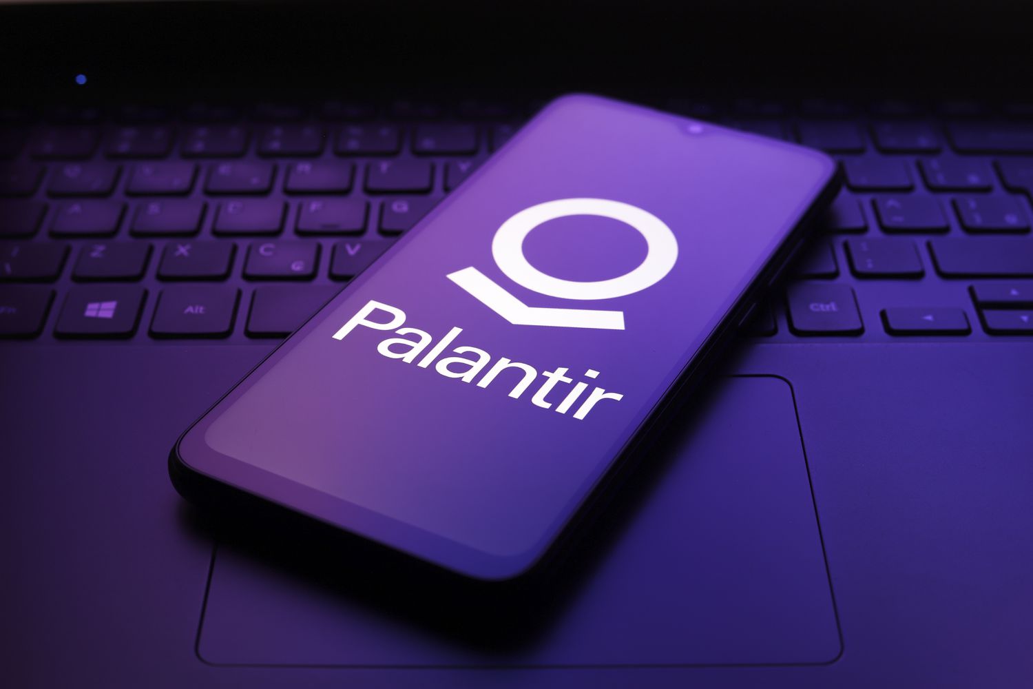 The Palantir Technologies logo appears on the screen of a smartphone