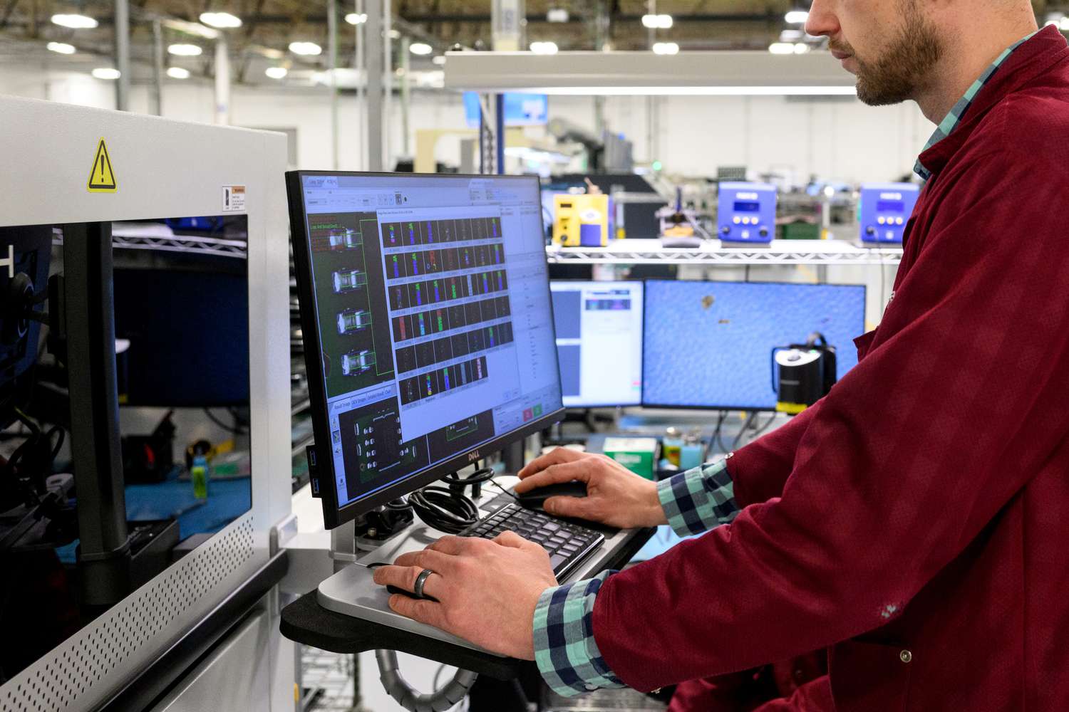 A worker uses a computer to assemble printed circuit board at the Intervala manufacturing facility in Mount Pleasant, Pennsylvania