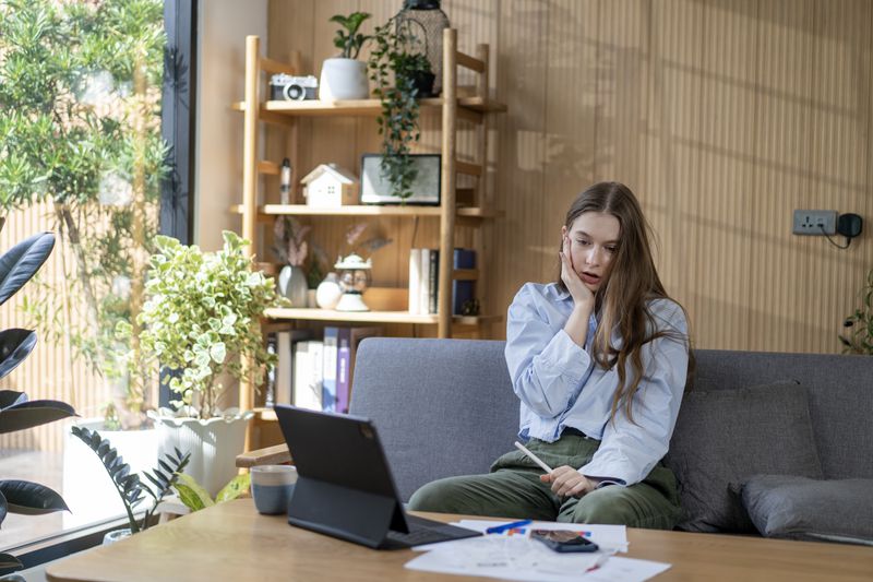 Young homeowner feels stressed when calculating the cost of selling a home.