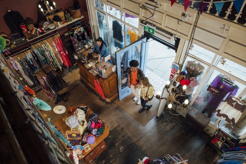 An overhead view of two people entering a vintage clothing store. 