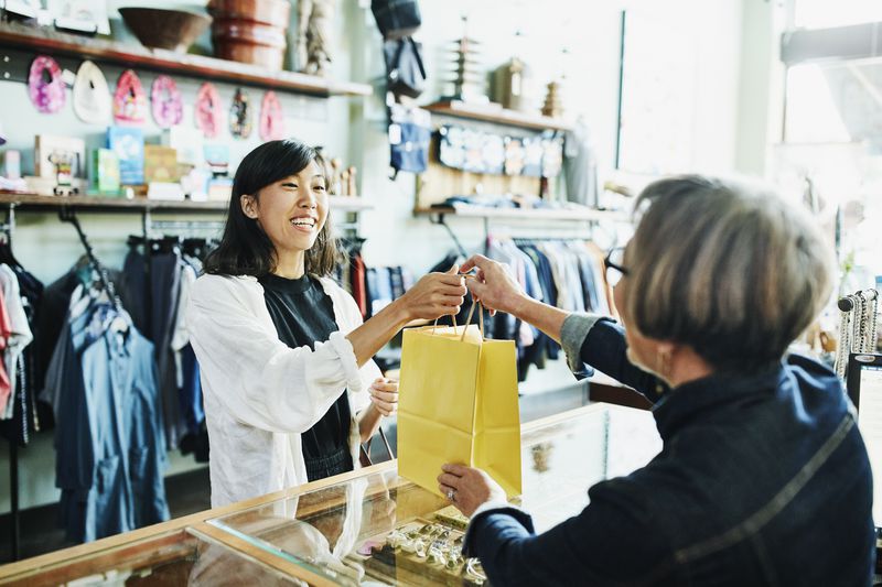A woman buys an item in a retail store.