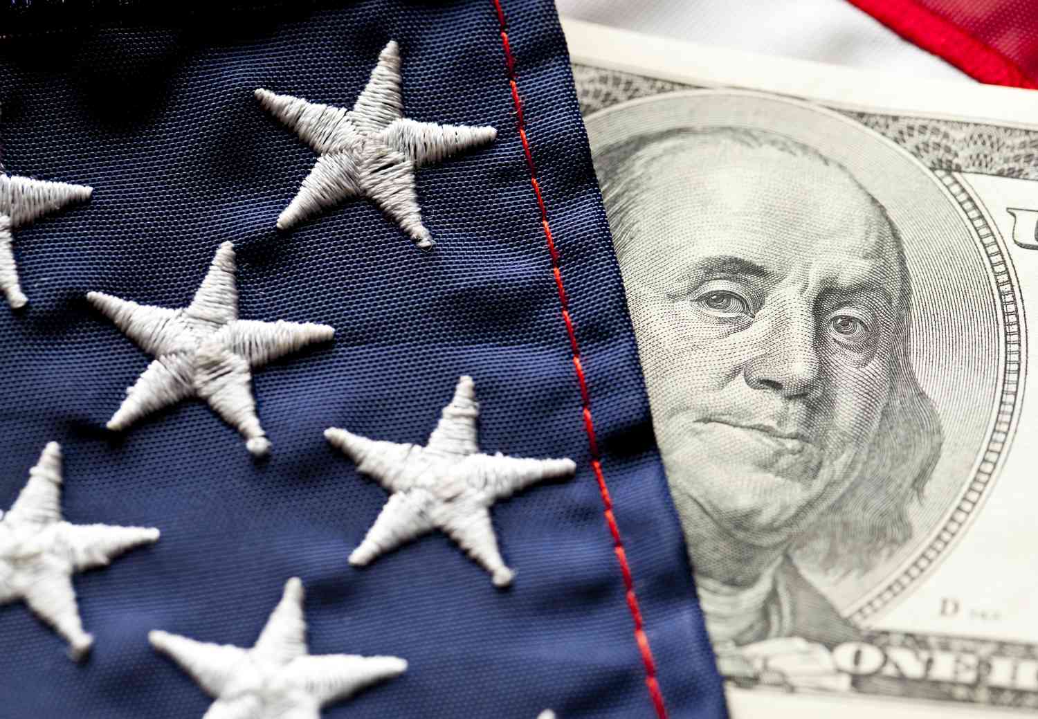 Close-up of U.S. flag and $100 U.S. bill