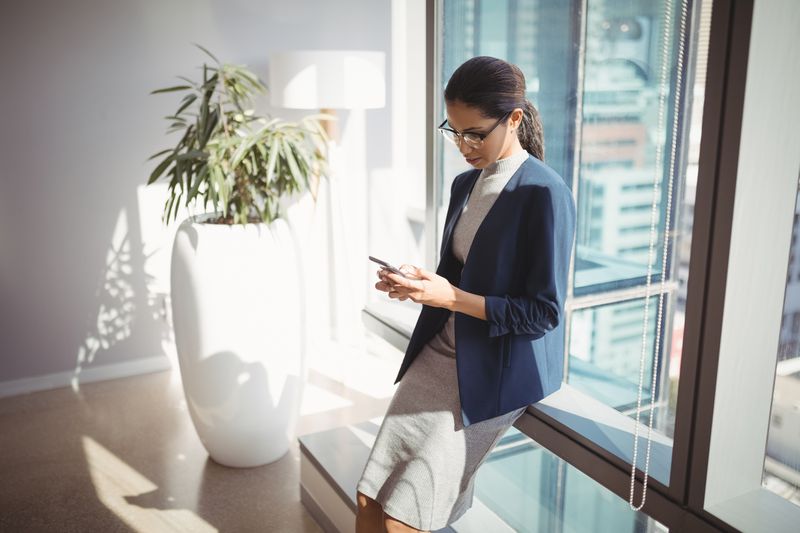 An employee checks her phone in an office.