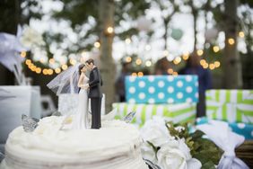 Bride and groom cake topper on cake.