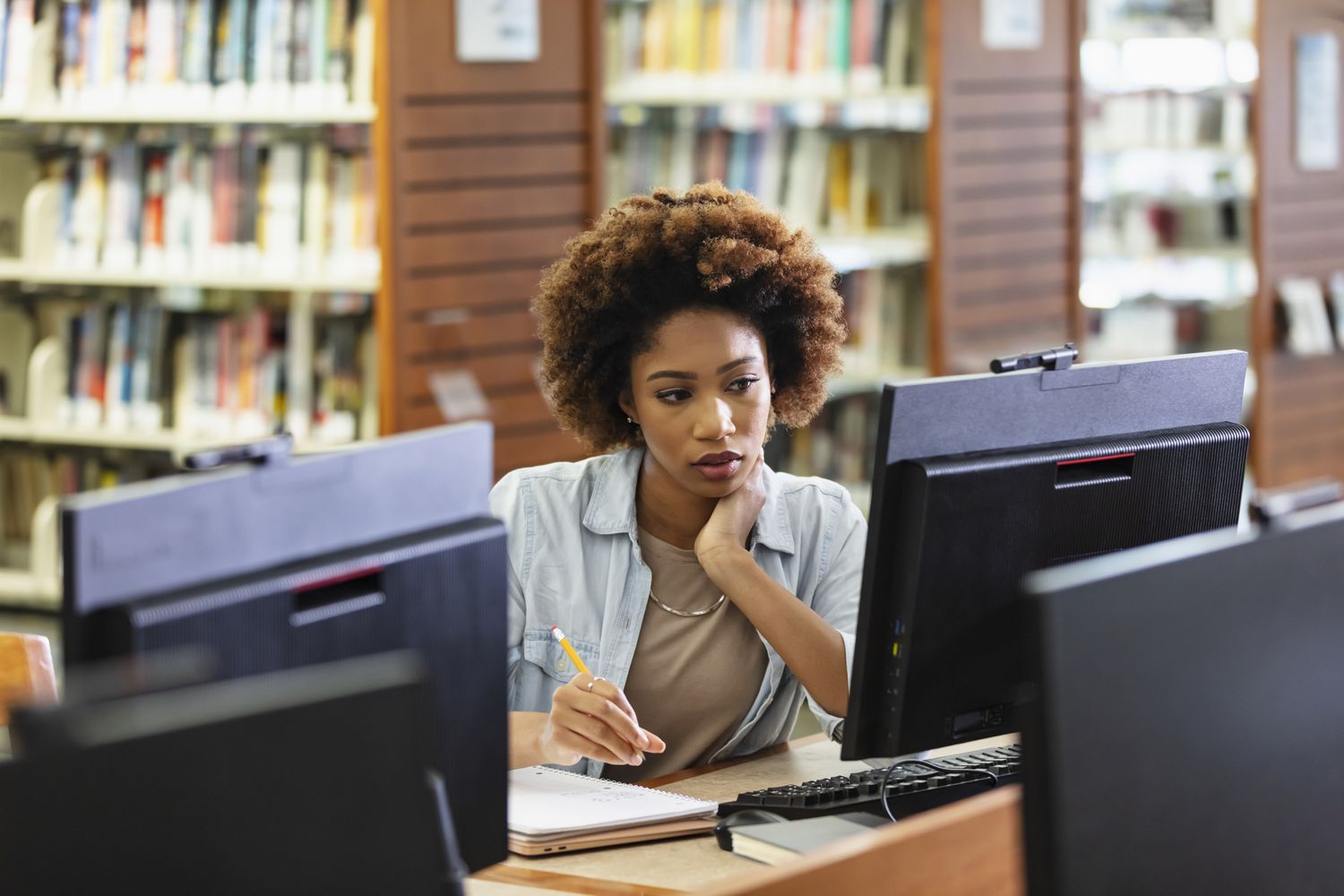 Woman researching how to find scholarships in her local library