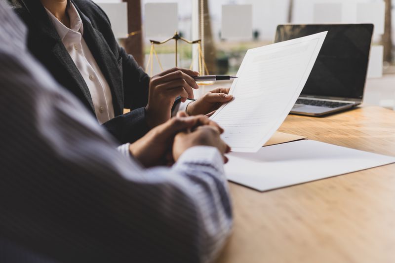Lawyer is checking documents with client and giving advice to avoid bona fide error.