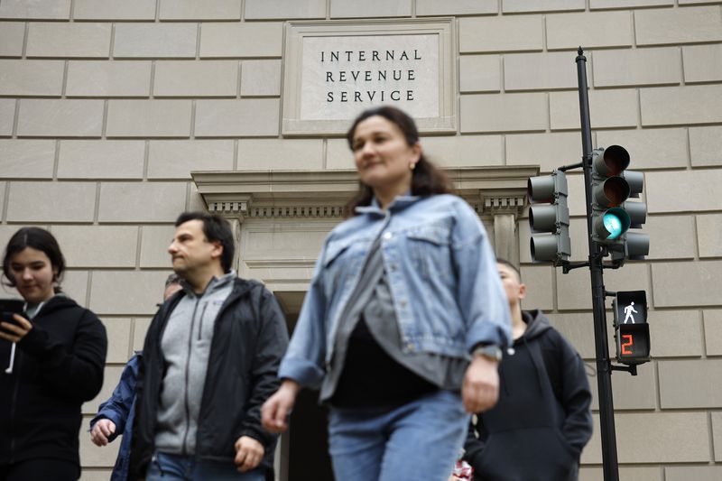 Tourists walk past the headquarters of the Internal Revenue Service.