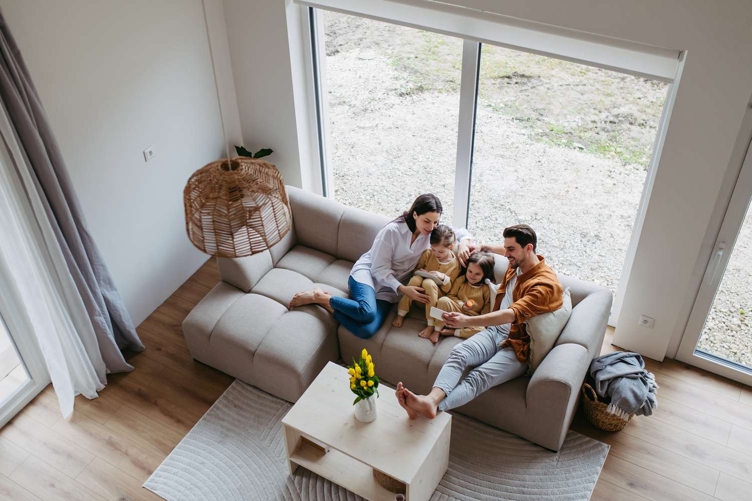 Aerial view of a family of four with two young kids sitting on a sofa.