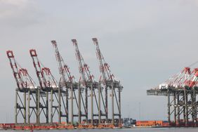 Several gray, red, and white cranes are seen above a port in New Jersey.