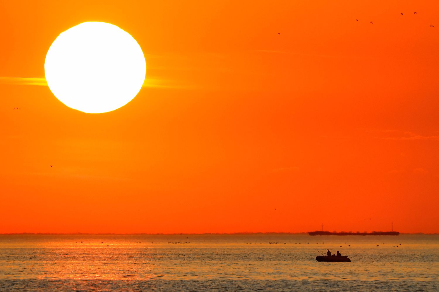 People sail on a boat in the Gulf of Finland during sunset.