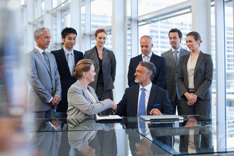 Business people shaking hands in conference room