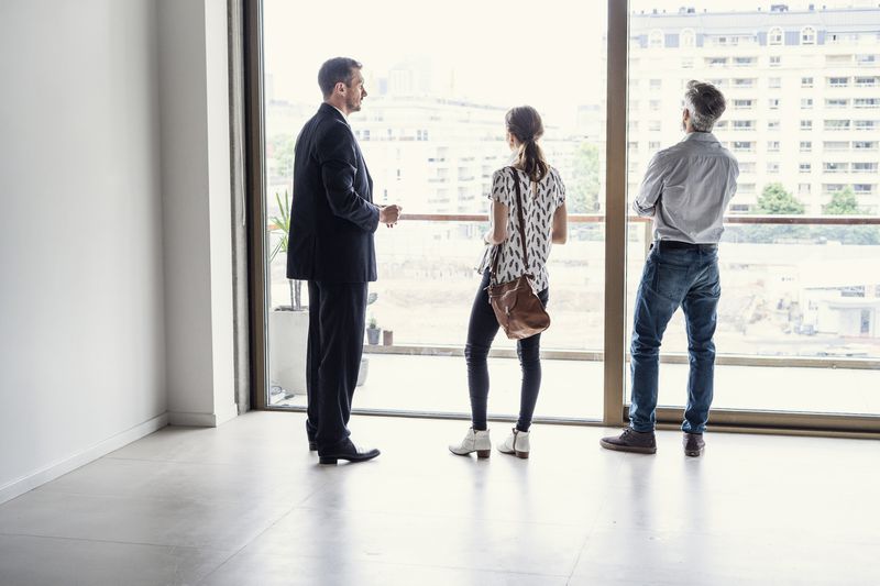 real estate agent showing a house to a man and woman