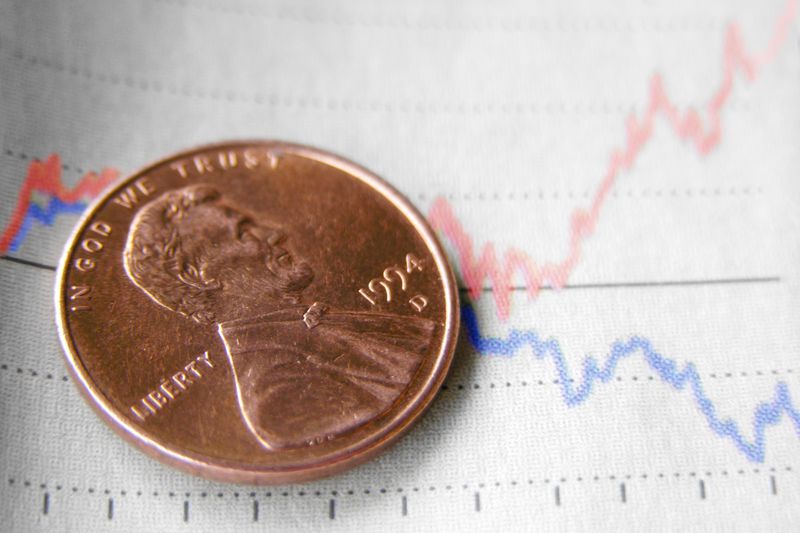 A penny on a market chart.
