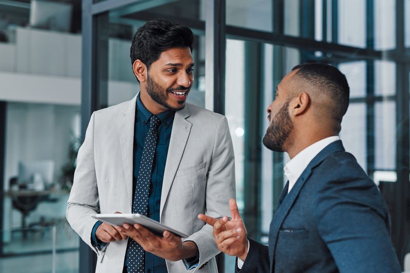 Man talks to his financial advisor about how his mortgage refinancing will affect his FICO score