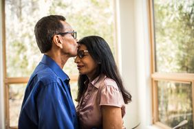 Senior man kissing wife at home
