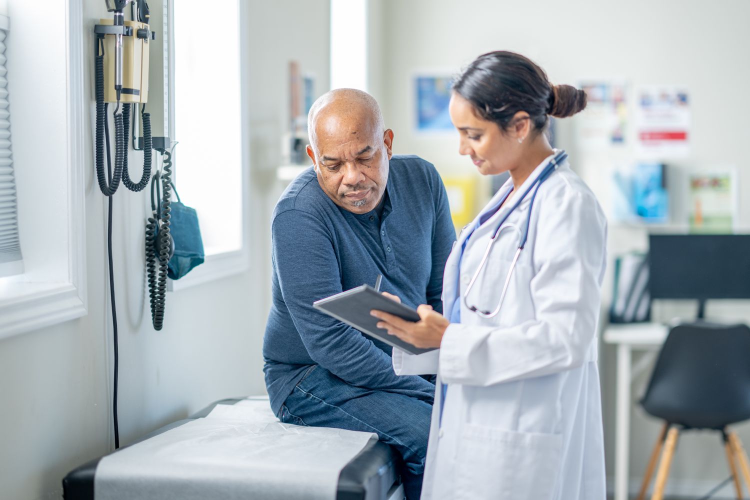 A senior man discusses recent test results with his doctor.