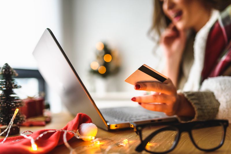 Young woman buying online at home for winter holidays using laptop computer. 