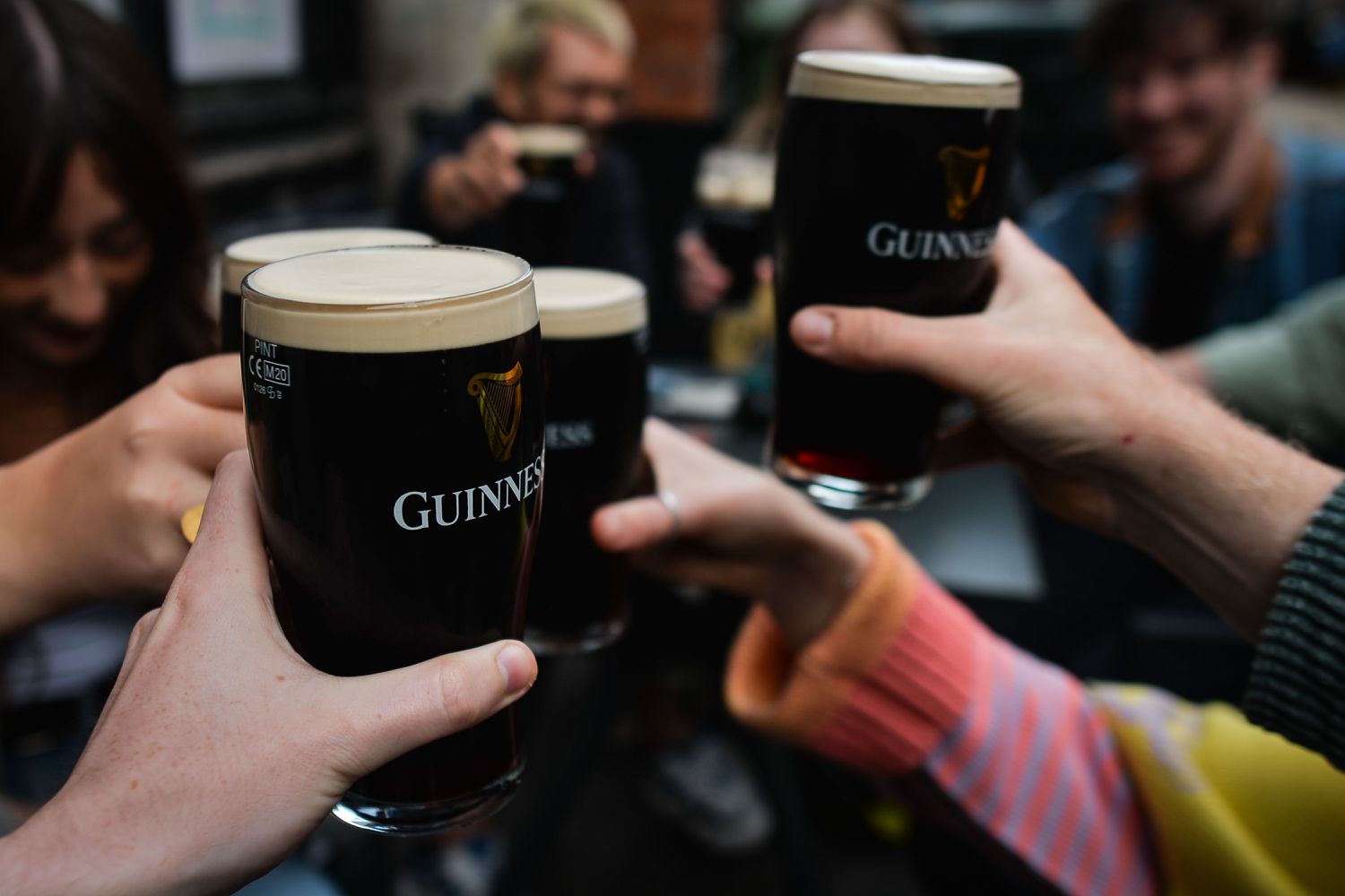 People drinking Guinness outside a pub.